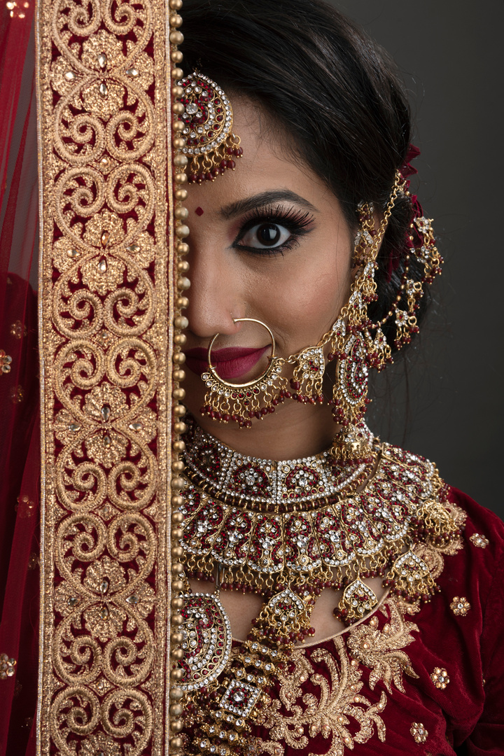Young Indian woman in bridal wear, jewelry and make-up
