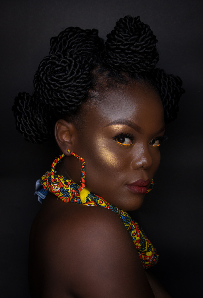 Woman with Gold Makeup, Colorful Jewelry, and Bantu Knots