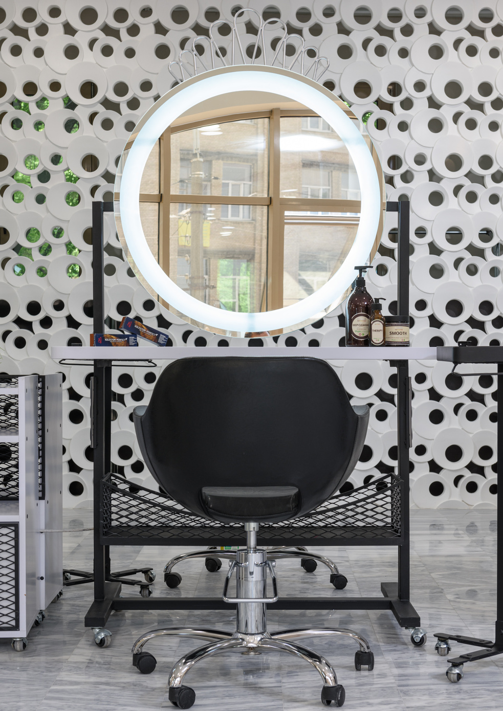 Photo of a Black Chair and a Mirror with a Ring Light